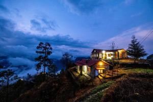 a house sitting on top of a hill at night at Breezy Affair -Binsar View Boutique Room in Binsar +18 photos