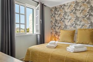 a bedroom with a bed with two towels on it at Villa Pedreiro in Funchal