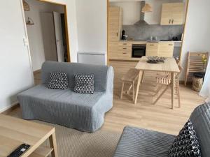 a living room with a blue couch and a table at Chez Bobo in Pont-du-Château