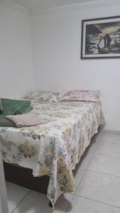 a bedroom with a bed with a flowered blanket on it at Casa Margarida in Brasília