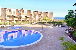 a large courtyard with a swimming pool in front of a building at Sea view La Tejita in Granadilla de Abona