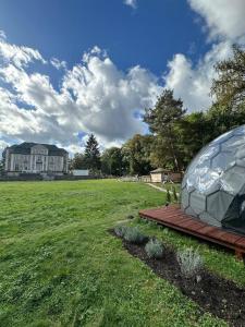 a dome tent in a field with a house in the background at Paradiesufer am See in Milmersdorf
