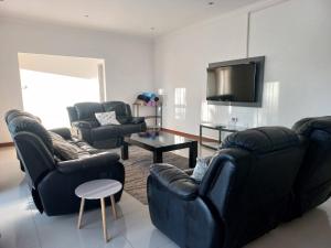 a living room with two couches and a flat screen tv at Comfortable and luxurious stay in Gweru
