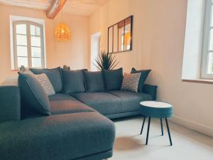 a living room with a couch and a table at Airkeys La Calade - Pied à Terre Authentique Idéal pour Groupe d'Amis & Famille en Escapade Luberon - Calme - CENTRE HISTORIQUE Pertuis - Aix-en-Provence 30min - Lourmarin 20min - WIFI HD in Pertuis