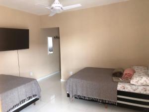 una camera con due letti e un bambino che dorme su di loro di Casa de campo a Paty do Alferes