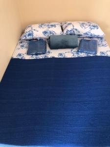 un letto con lenzuola e cuscini blu e bianchi di Casa de campo a Paty do Alferes Altre 8 foto