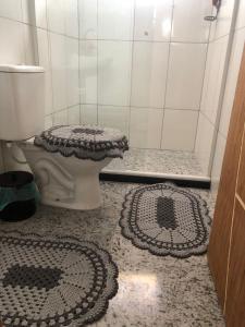 bagno con servizi igienici e 2 tappeti sul pavimento di Casa de campo a Paty do Alferes
