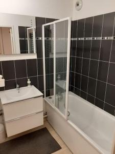 a bathroom with a shower and a tub and a sink at Joli appartement avec Jardin et 2 parkings privés in Argenteuil +11 photos