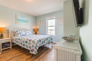 a bedroom with a bed and a television and a window at Walk to Beach Family-Friendly Surf City Condo! in Surf City