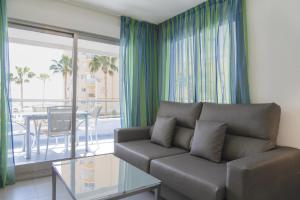 a living room with a couch and a glass table at Apartamentos Hipocampos Calpe Rent Apart in Calpe
