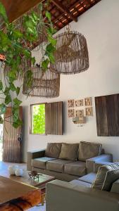 a living room with a couch and some plants at A Casa de Ponta-Simplicidade e Requinte -Estrutura Completa a 150m da praia in Maragogi