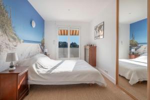 een slaapkamer met twee bedden en een spiegel bij Appart vue mer pour 4 à St Brevin les Pins in Saint-Brevin-les-Pins