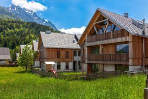a house in a field with mountains in the background at Apartment Pr Cirklu, Kranjska Gora in Kranjska Gora