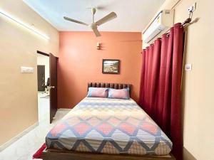 加尔各答Cozy 2BHK Apt near Ruby Hospital & EM Bypass的一间卧室配有床和红色窗帘