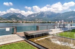 a park with a fountain with a view of the mountains at La finestra sul lago in Malgrate