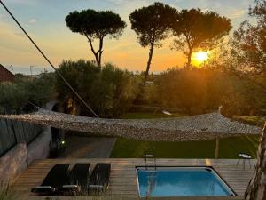 a hammock on a house with a swimming pool at Sea view villa in Olive Garden in Nea Kallikrateia
