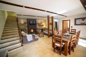 a living room with a dining table and a fireplace at Finca Los Olivos in Alcalá del Júcar