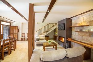 a living room with a fireplace and a staircase at Finca Los Olivos in Alcalá del Júcar