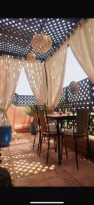 patio con tavolo e sedie sotto ombrellone di Très joli appartement à Atlas Golf Resort a Marrakech
