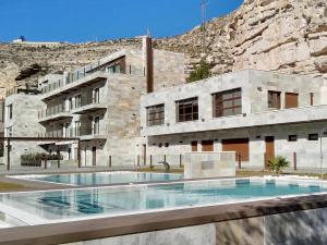 a building with a swimming pool in front of a mountain at Finca Los Olivos in Alcalá del Júcar