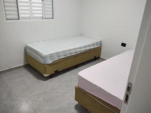a bedroom with two beds in a room at Casa de Praia Golfinhos in Caraguatatuba