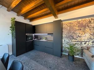 a kitchen with black cabinets and a sink at elegant Bike&Moto Haven in Gavardo