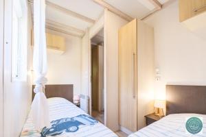 a bedroom with a bed with a canopy at Chalet en Parc résidentiel pour 4 personnes à proximité de la plage in Lit-et-Mixe +17 photos