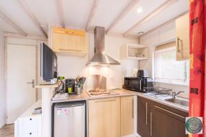 a small kitchen with a sink and a stove at Chalet en Parc résidentiel pour 4 personnes à proximité de la plage in Lit-et-Mixe