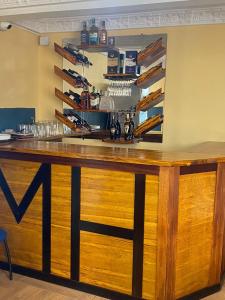 a bar with a wooden counter with glasses at Ma'a Lapseu hôtel in Yaoundé
