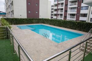 a swimming pool in front of a building at Bela Getaway Homes Elegant One bedroom Apartment in Nairobi