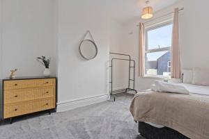 Un dormitorio con una cama y una cómoda y una ventana. en 4 Bedroom House in Central Location with Free Parking, Self-Check-In, Fast WiFi & Smart TV with Netflix by Yoko Property, en Redcar 17 fotos más