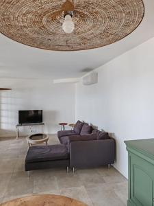 a living room with a couch and a ceiling at L'Occitane bleu in Sète