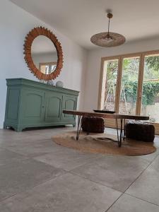 a living room with a table and a mirror at L'Occitane bleu in Sète