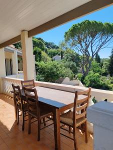 a wooden table and chairs on a patio with a view at L'Occitane bleu in Sète
