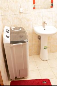 a bathroom with a toilet and a sink at Mayfair 1 Bedroom-Bukoto in Kampala