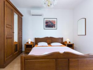 Studio Beach Villa Baška في باشكا: غرفة نوم بسرير خشبي وموقف ليلتين