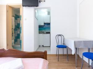 Studio Beach Villa Baška في باشكا: غرفة نوم بها سرير وطاولة وكراسي