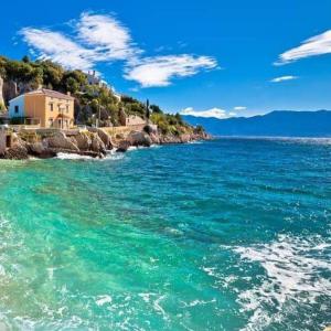 Studio Beach Villa Baška في باشكا: a large body of water with a house on the shore