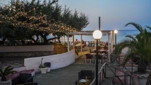 a patio with a bar with lights and the ocean at Centro Turistico San Nicola in Peschici