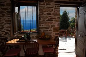 a table and chairs in a room with a window at Sweet Stone Cottage in Tsagarada