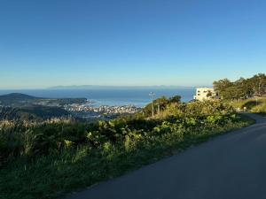a winding road with the ocean in the background at Otaru Garden Stay in Otaru