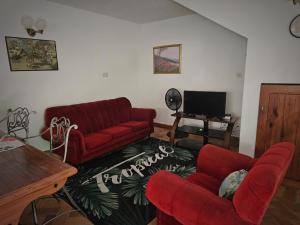 a living room with a red couch and two chairs at Kaye Jacquot in Monchy