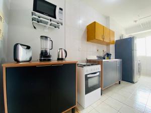 a kitchen with a stove and a refrigerator at Apê completo bem no centro in Joinville +19 photos