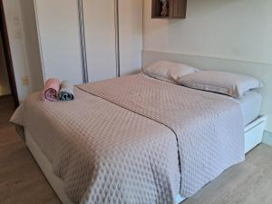 a bed with pink and white sheets and pillows at Suíte Pé na Areia do Flamengo in Salvador