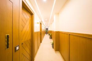 a hallway with wooden doors and a long corridor at Alaya Stays 3 BHK With Garden - Evaara Woods Breeze in Shimla