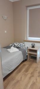 Melafir Pensjonat في لوندك زدرووي: غرفة نوم بها سرير وطاولة ونافذة