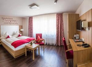 a hotel room with a bed and a desk at Landgasthaus zur Linde in Bühl