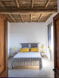 a bedroom with a large bed with yellow pillows at La Casa di Pan in Bullicame