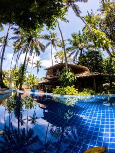 a pool at a resort with palm trees at Pousada Maré Alta in Marau