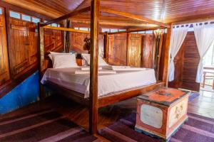 a bedroom with a bed in a wooden room at Pousada Maré Alta in Marau